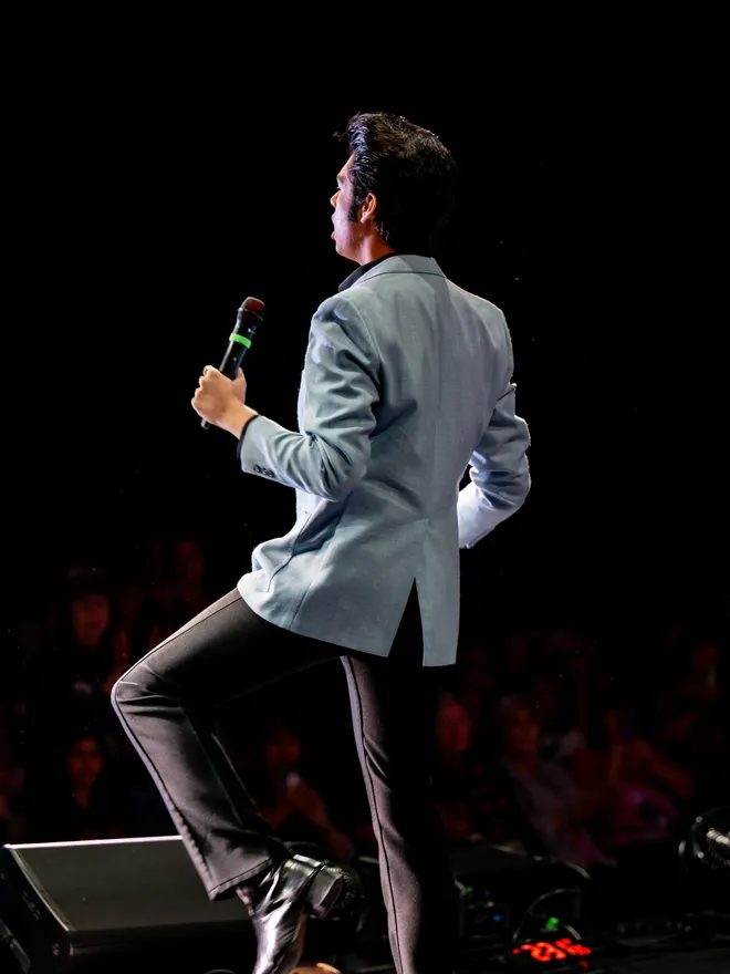 Finley Watkins standing on stage with a microphone
